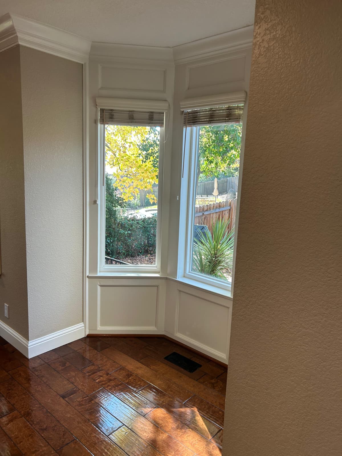 Clean bay window space with polished hardwood flooring