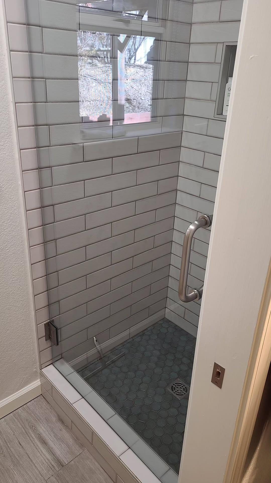 Clean tiled shower with clear glass door