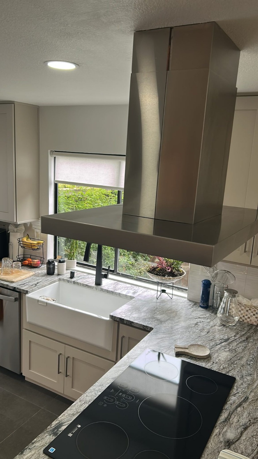 Finished modern kitchen with bright sink and steel hood