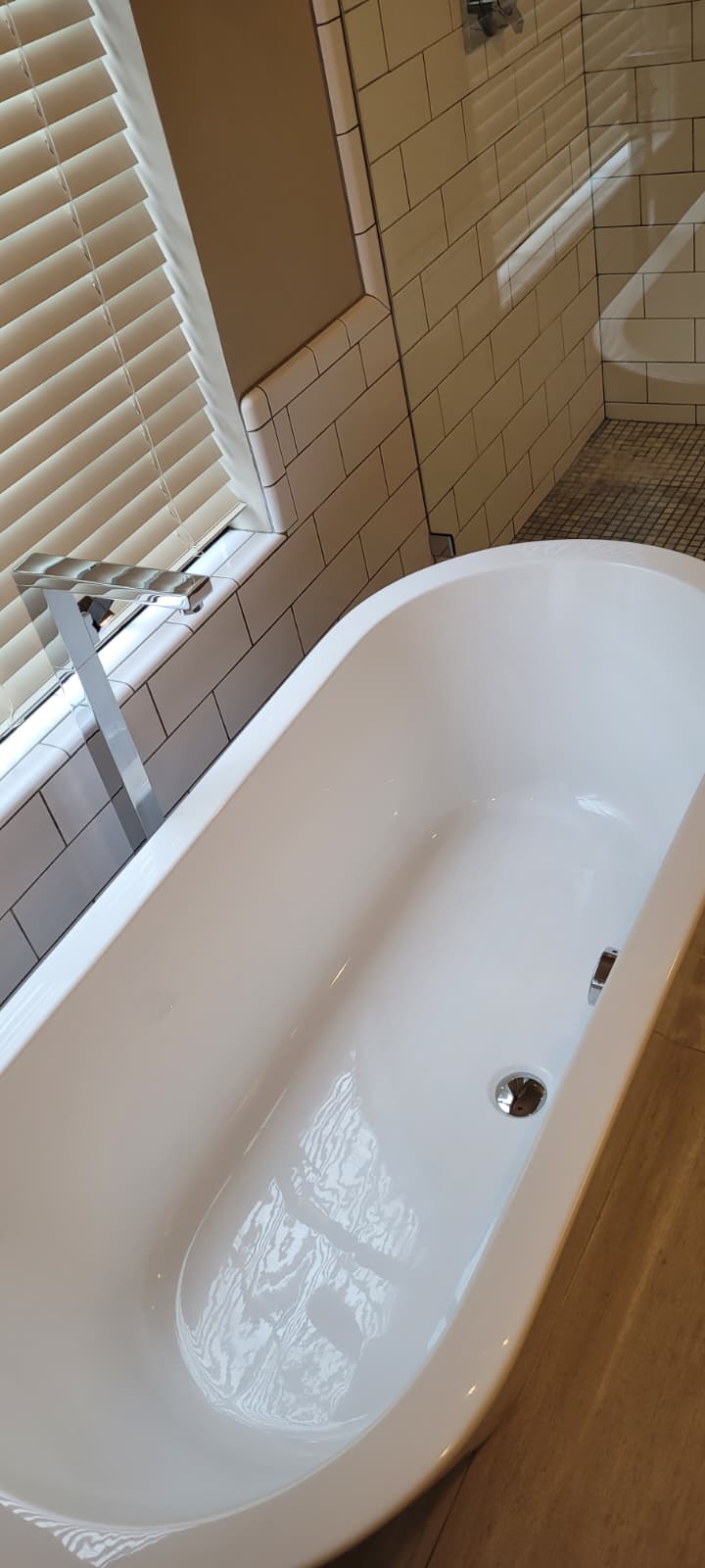 Pristine white soaking tub beside a bright window